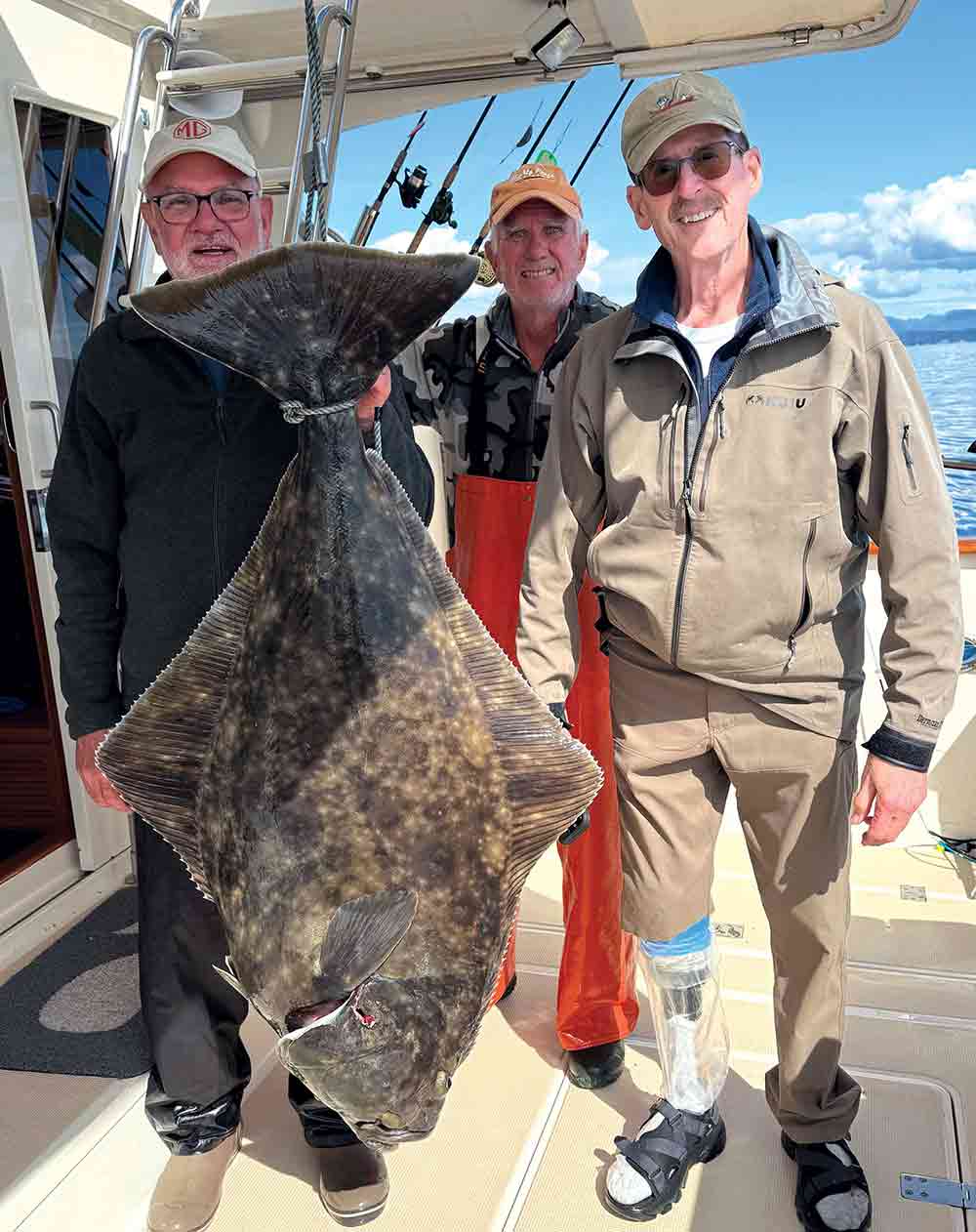 Greg, Steve, and Rick pose with a 70-pound halibut caught near Angoon, Alaska, during a coho and halibut fishing trip.