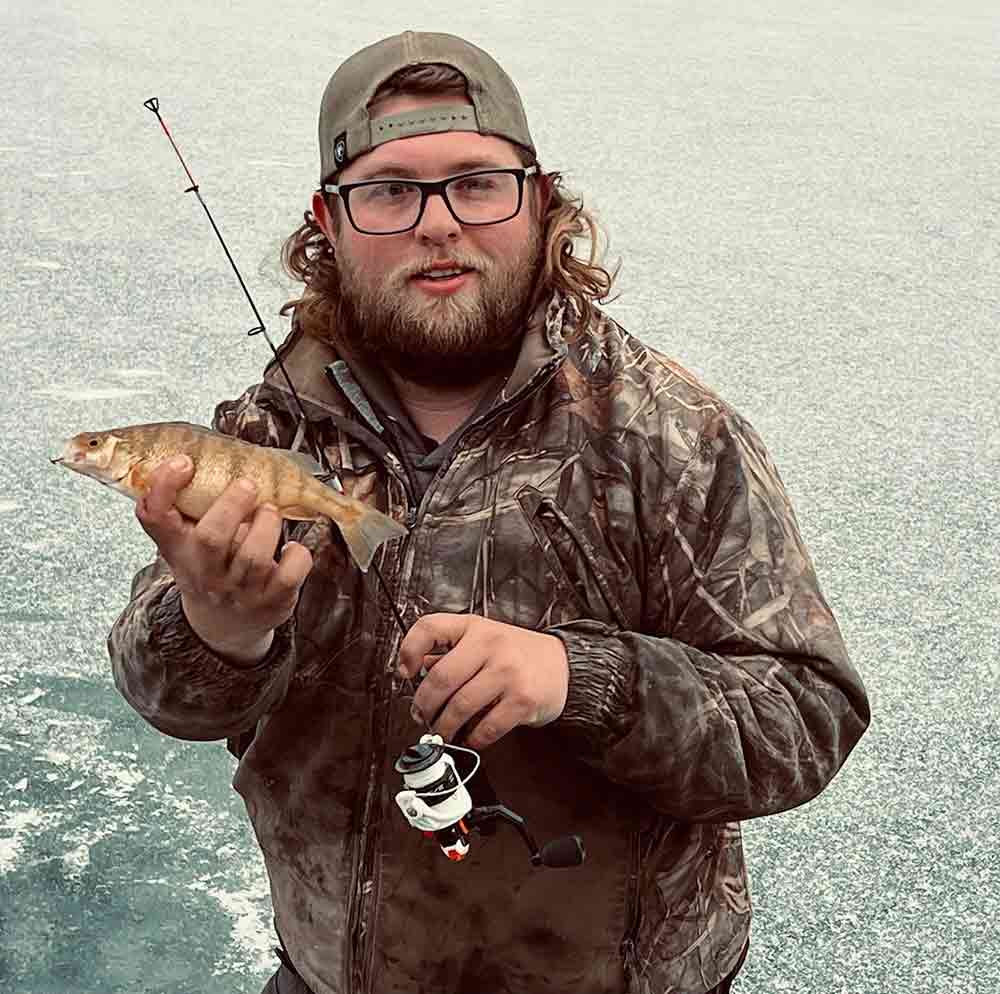 Tyler Bergquist ice fishing at Red Rock Lake near Royal City with a heater-equipped hut and a bag of keeper perch.