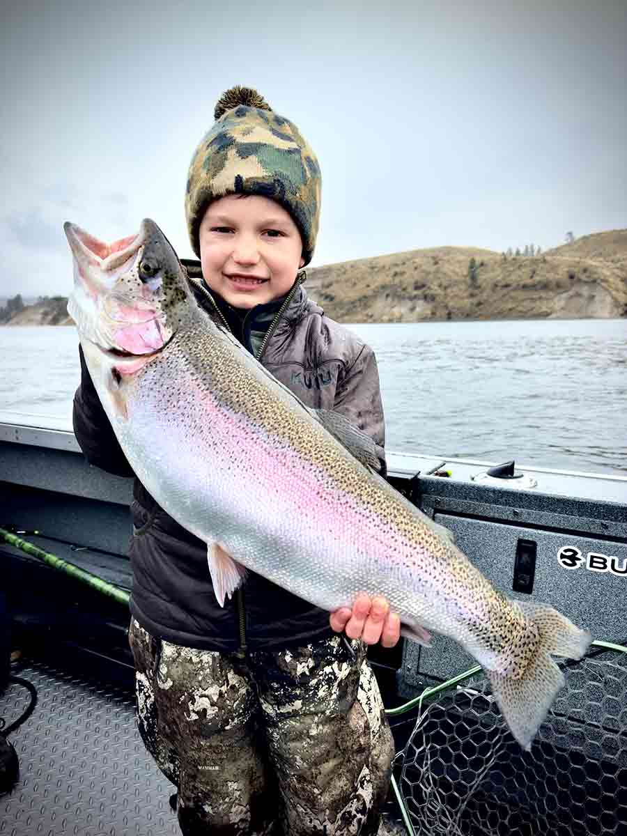 A young angler proudly holds a 12-pound triploid trout caught at Rufus Woods Reservoir.